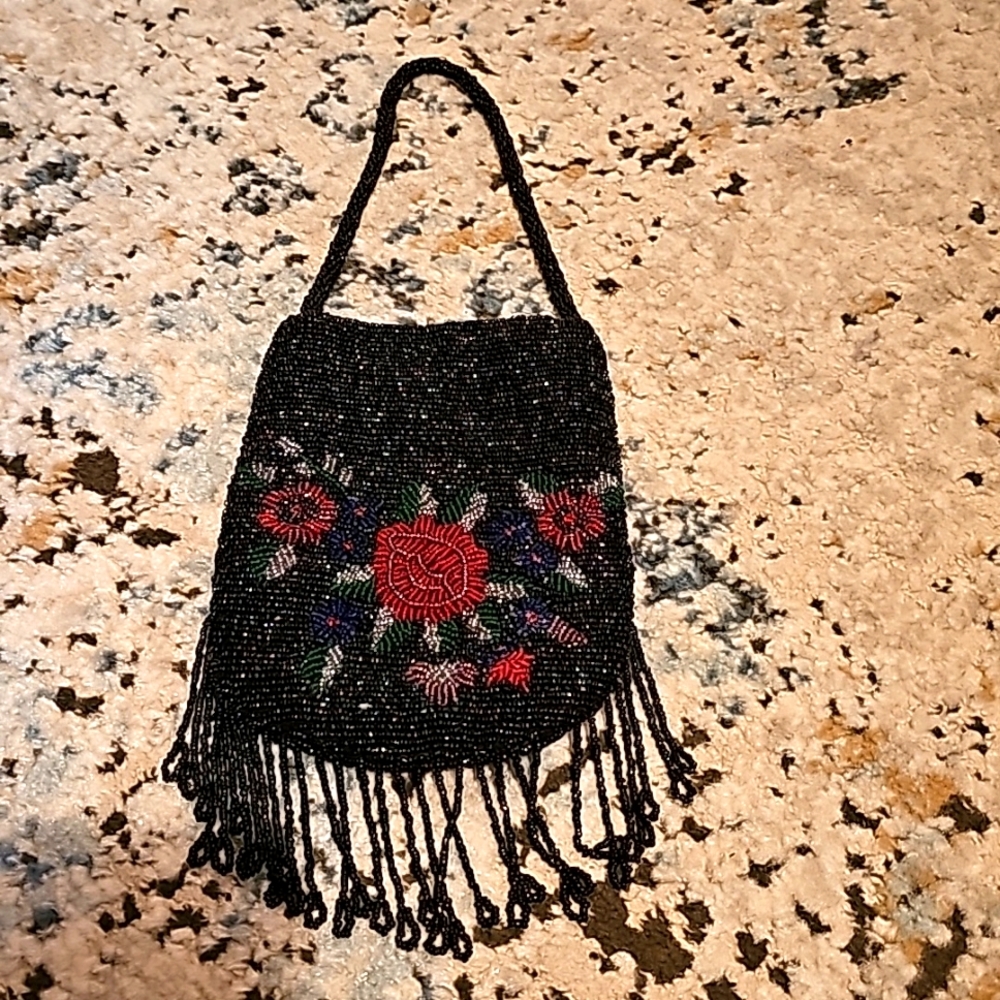 Small black micro beaded handbag purse with floral design and beaded fringe.